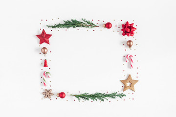 Christmas composition. Frame made of christmas tree branches, red and golden decorations on white background. Flat lay, top view, copy space