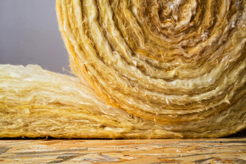 roll of mineral wool lying on the wooden floor