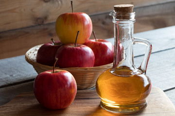 A bottle of apple cider vinegar with apples