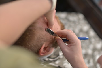 Correction of beard and haircuts in barbershop. Haircut of a man.