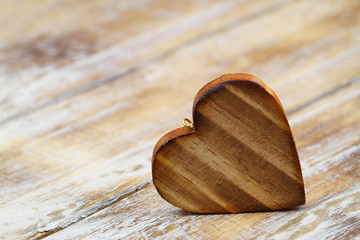 Brown wooden heart on rustic surface with copy space
