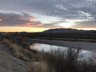 Reflection of sunset in the river along a walking trail