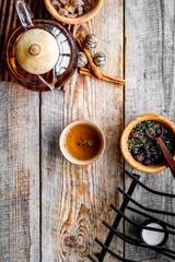 Tea ceremony concept. Tea pot, cups, dry tea leaves, sugar on rustic wooden background top view copyspace