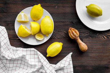 Wooden juicer for making lemonade on dark wooden background top view