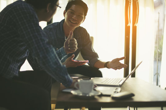 Happy business people looking at report and having a discussion in office.