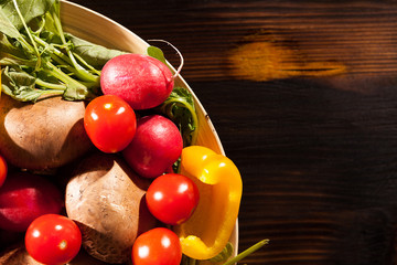 Different type of fresh organic vegetables on burned wooden background in studio photo