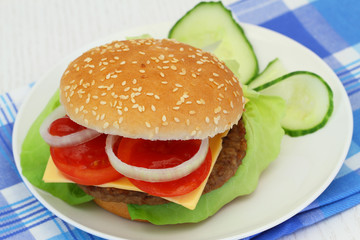 Cheeseburger on white plate, closeup
