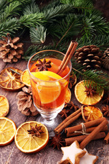 glass of hot mulled wine with oranges and spices.