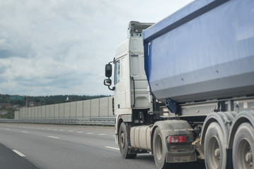 Obraz na płótnie Canvas A lorry with tipping trailer in motion on the motorway.