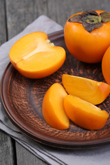 Japanese persimmons in ceramic plate. Closeup