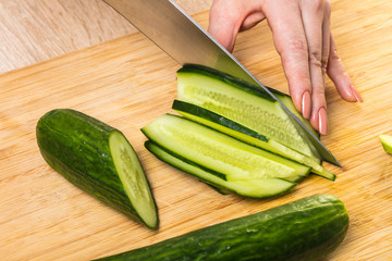 chef cuts cucumber with a knife