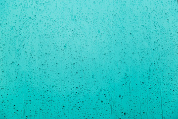 drops of rain on a glass on a multicolored background