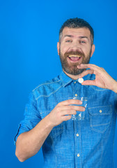 Man with beard hold water glass on blue background, headache.
