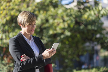 Fototapeta premium Executive working with a mobile phone in the street
