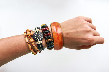 Fototapeta premium Ethnic bracelets on a thin female hand on white background