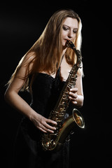 Obraz na płótnie Canvas Saxophone player. Saxophonist woman playing Sax