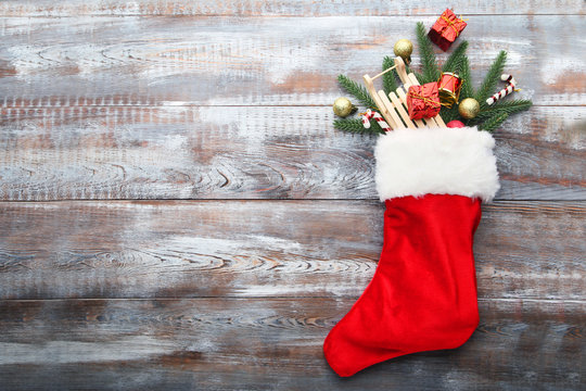 Red stocking and christmas decorations on wooden table