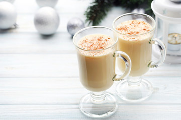 Eggnog in glasses on white wooden table