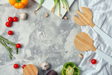 Fresh vegetables and kitchen utensils on light background
