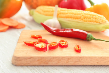 Board with chili pepper on table