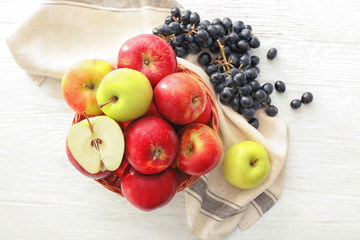 Composition with apples and grapes on wooden table