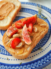 Fresh toast with peanut butter, fig and strawberry on stand