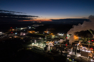 Fototapeta premium Aerial view of oil refinery. Industrial view at oil refinery plants with lots of light at night. Panorama.