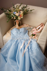 Wedding accessories for bride. Wedding morning and preparation. Blue wedding dress, pink shoes on high heelsa, bridal bouquet