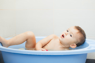 Obraz premium Happy baby boy taking a bath