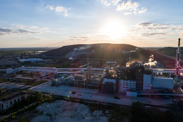 Obraz premium Aerial view Oil refinery with a background of mountains and sky at sunset. Aerial photography. Kohtla-Järve city, Estonia, Ida-Virumaa.