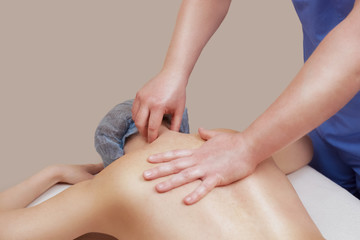 The masseur makes a massage on the back of the patient in the beauty salon. Medical care for the...