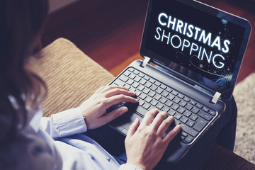 Woman doing Christmas Shopping with a laptop at home.