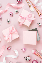 Flat Lay Holiday Background with Christmas ball, gift, ribbon and decorations in pastel pink colour. Flat lay, top view