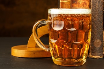 Glass of cold beer and old books. Rest with the book.