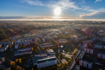 Aerial view of beautiful sunrise over the city. City in fog, misty landscape.