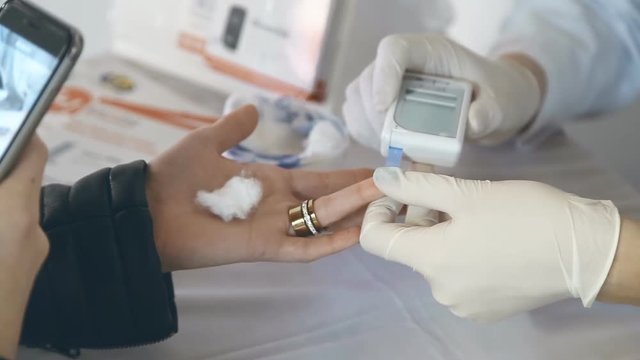 Closeup of nurse hands doing finger blood testing