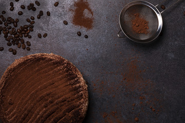Italian frozen cake - tiramisu dessert on a dark background with coffee beans and powdered cocoa powder