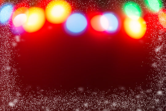 Blurred Christmas lights with red backround and snow flakes frame