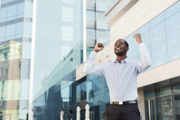 Happy excited businessman celebrate. Winner, black man outdoors