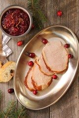 Overhead view of Sliced  roasted Turkey with cranberry sauce on wooden background