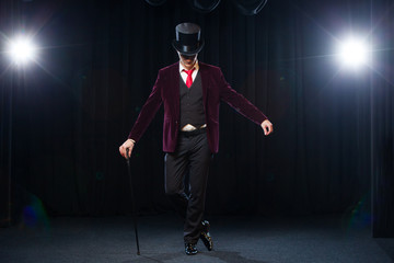 Magician, Juggler man, Funny person, Black magic, Illusion standing on the stage with a cane of...