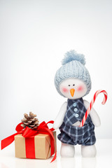Snowman doll and christmas gift box with a light gradient on the background