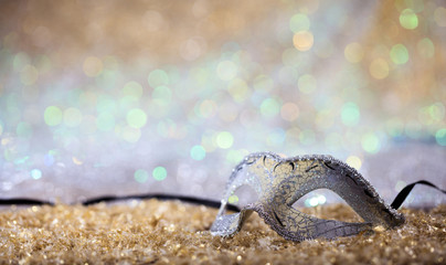 Silver carnival mask on bokeh background