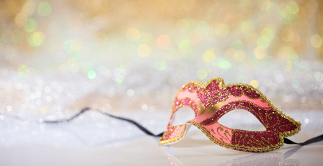 Pink carnival mask on bokeh background
