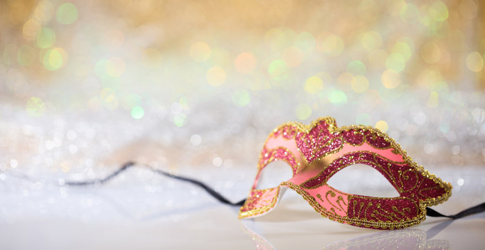 Pink carnival mask on bokeh background
