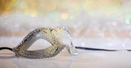 Silver carnival mask on bokeh background