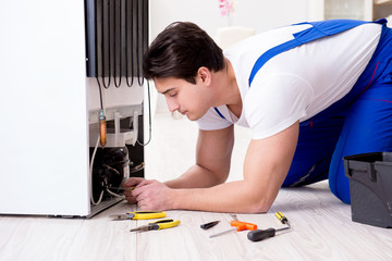 Repairman contractor repairing fridge in DIY concept