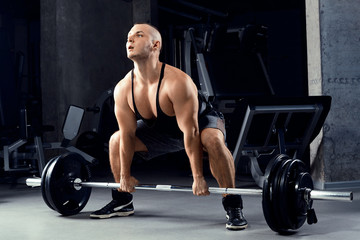 Fototapeta na wymiar Muscular men lifting deadlift In the gym