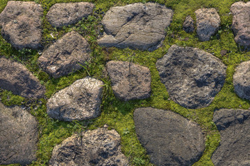 Fragment of the old road paved granite stones