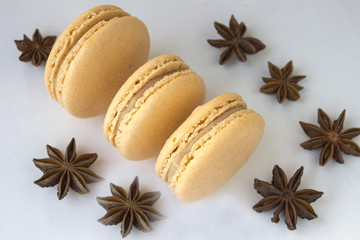 Sweet macarons, spices anise  on white background